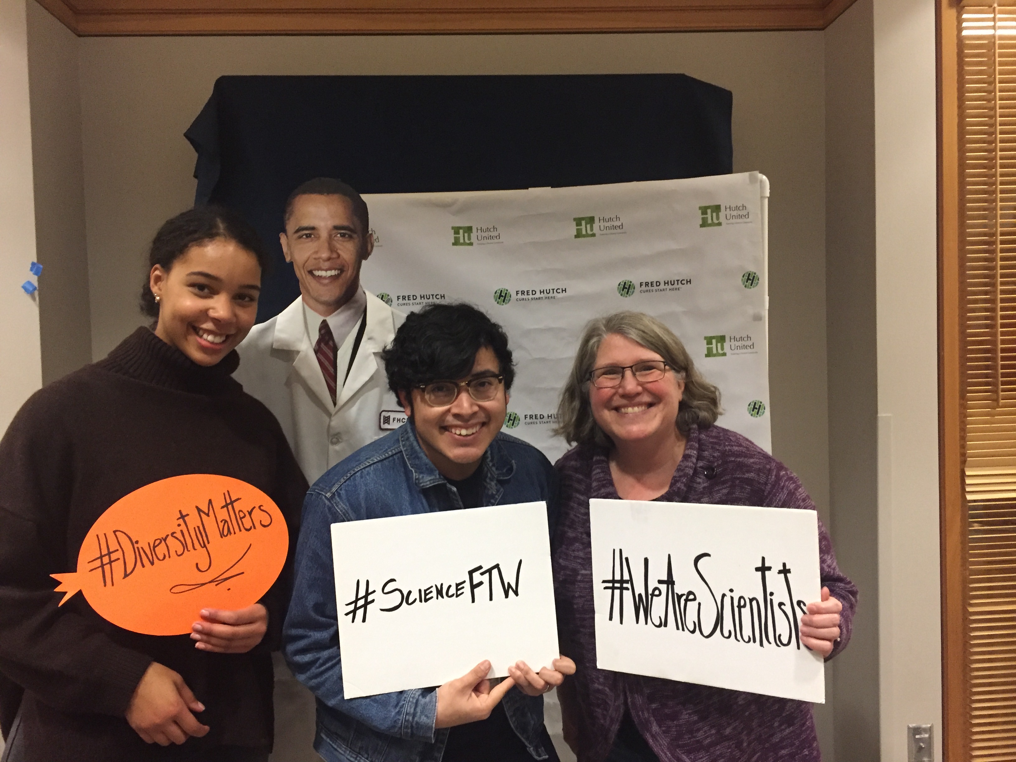 Diverse Boeckh lab team members hold up signs that say #DiversityMatters, #WeAreScientists, and #ScienceFTW