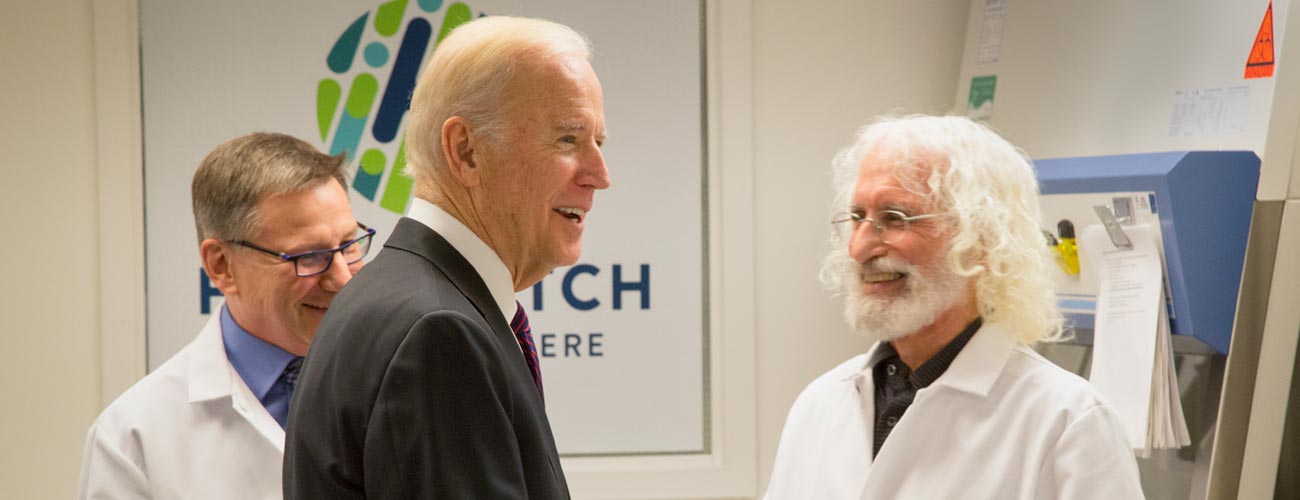 Vice President Joe Biden talks to cancer immunotherapy researchers Dr. Stan Riddell, left, and Dr. Phil Greenberg during a Fred Hutch lab tour.