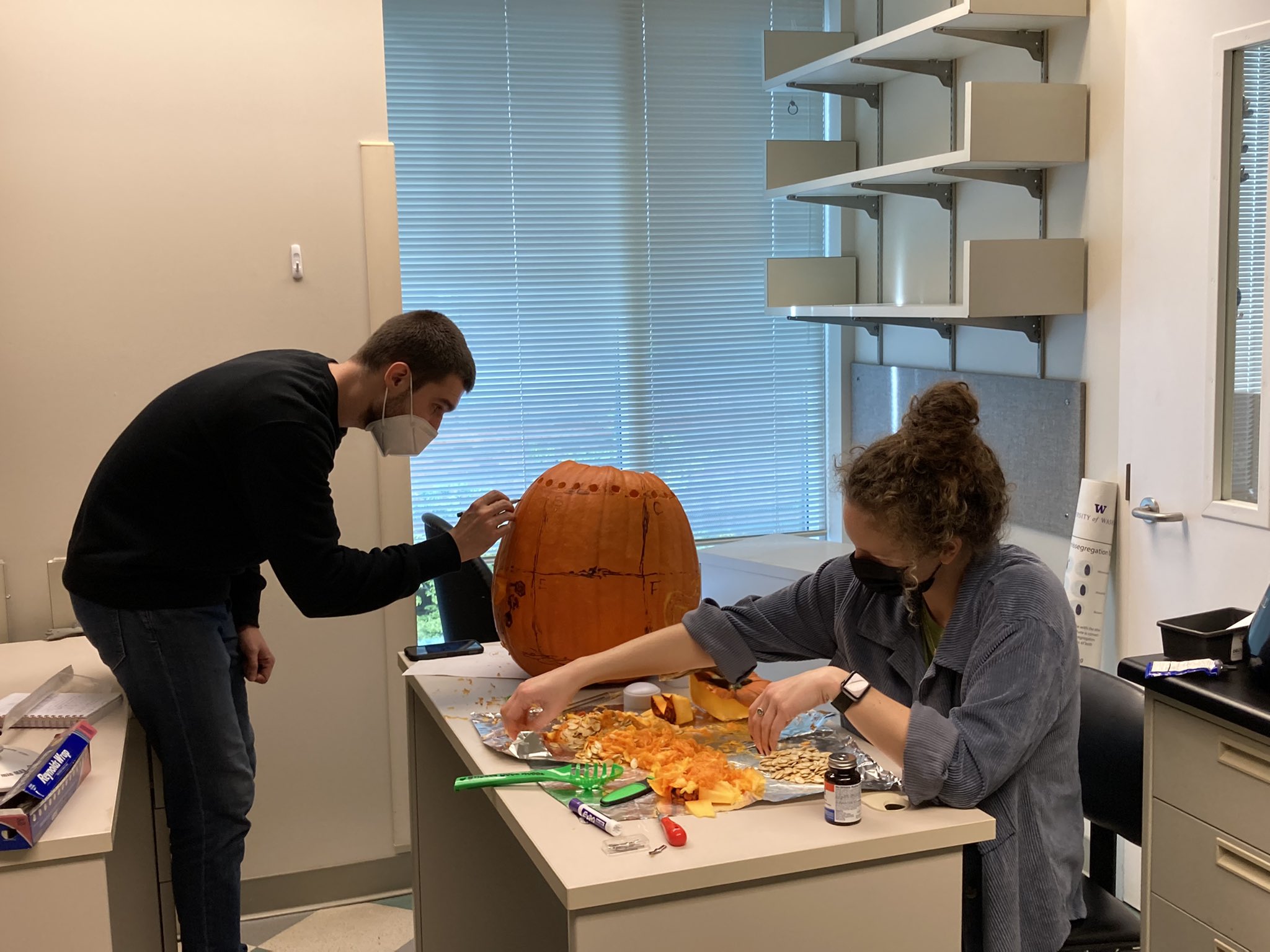 Lab members carving a pumpkin