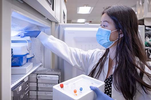 Research Technician Angela Yu retrieves a sample from the freezer