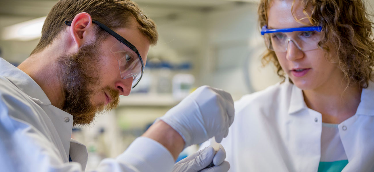 Jacob Hyer, left, working with Leah Homad in the McGuire Lab at the Fred Hutchinson Cancer Research Center